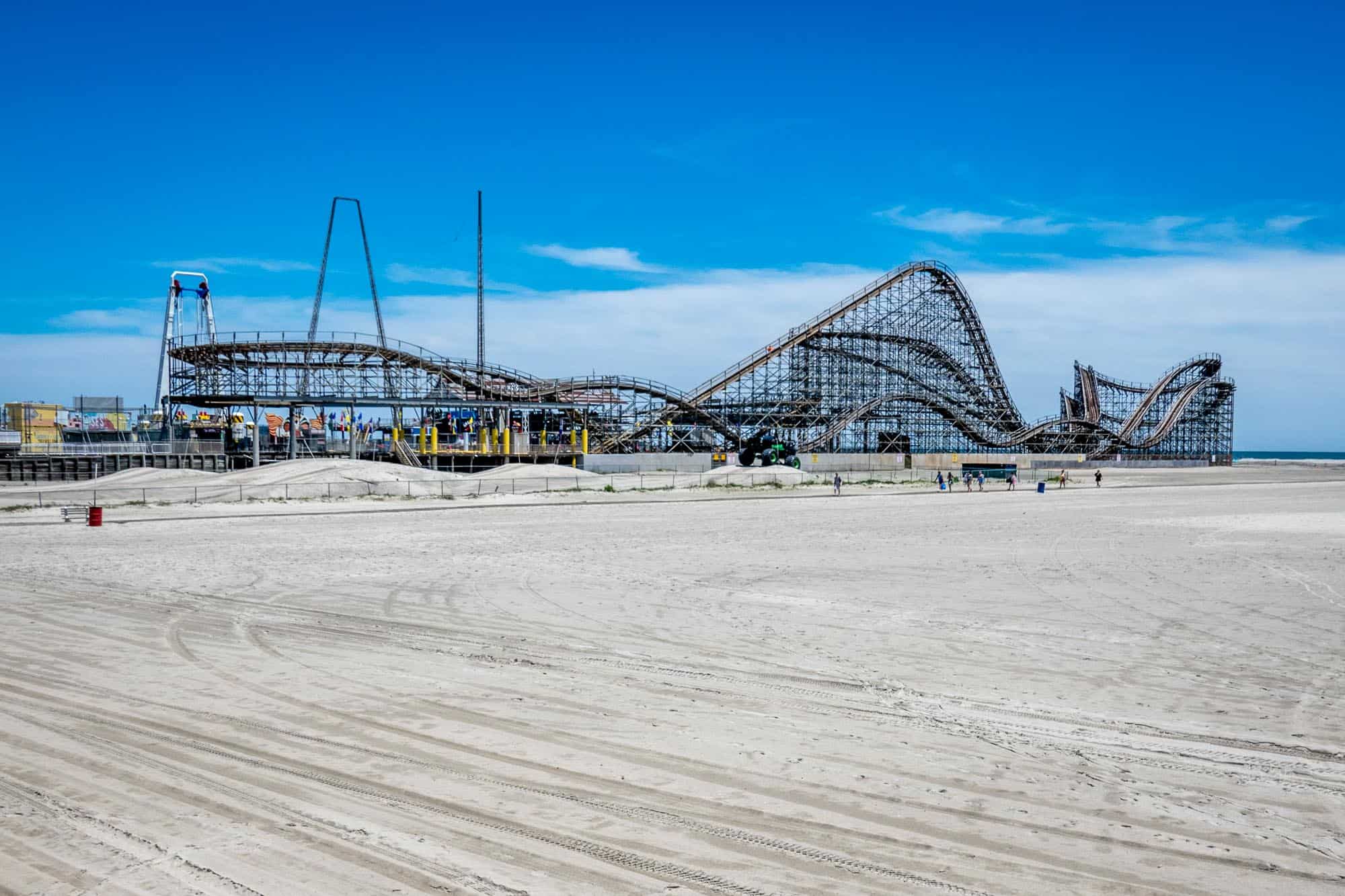 Rollercoaster and amusement park on a beach.