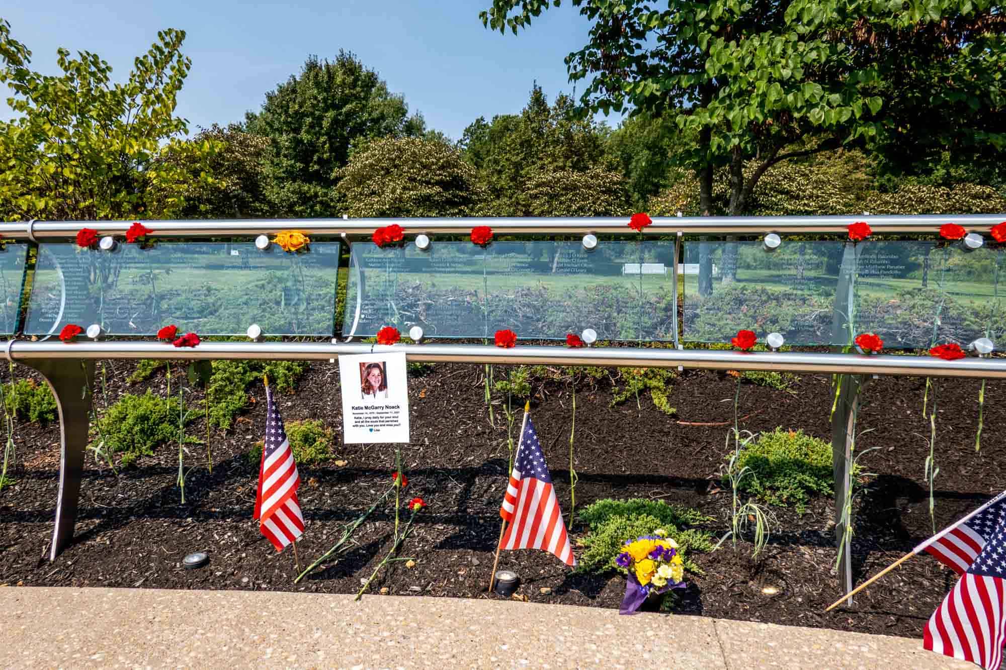 Names of those who died on September 11 carved into glass panels with flowers placed as memorials