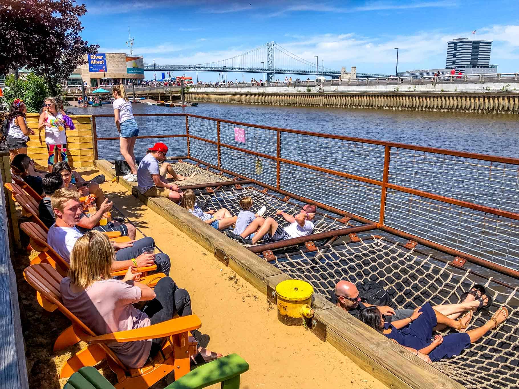 People lying in nets floating over Delaware River