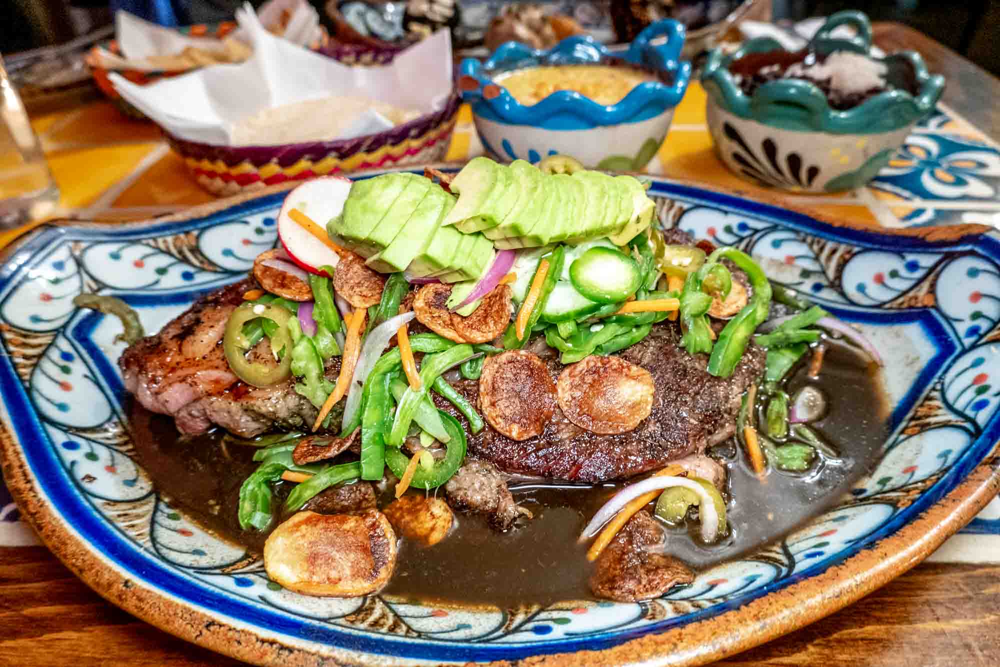 Steak topped with avocado, nopales, and jalapenos.