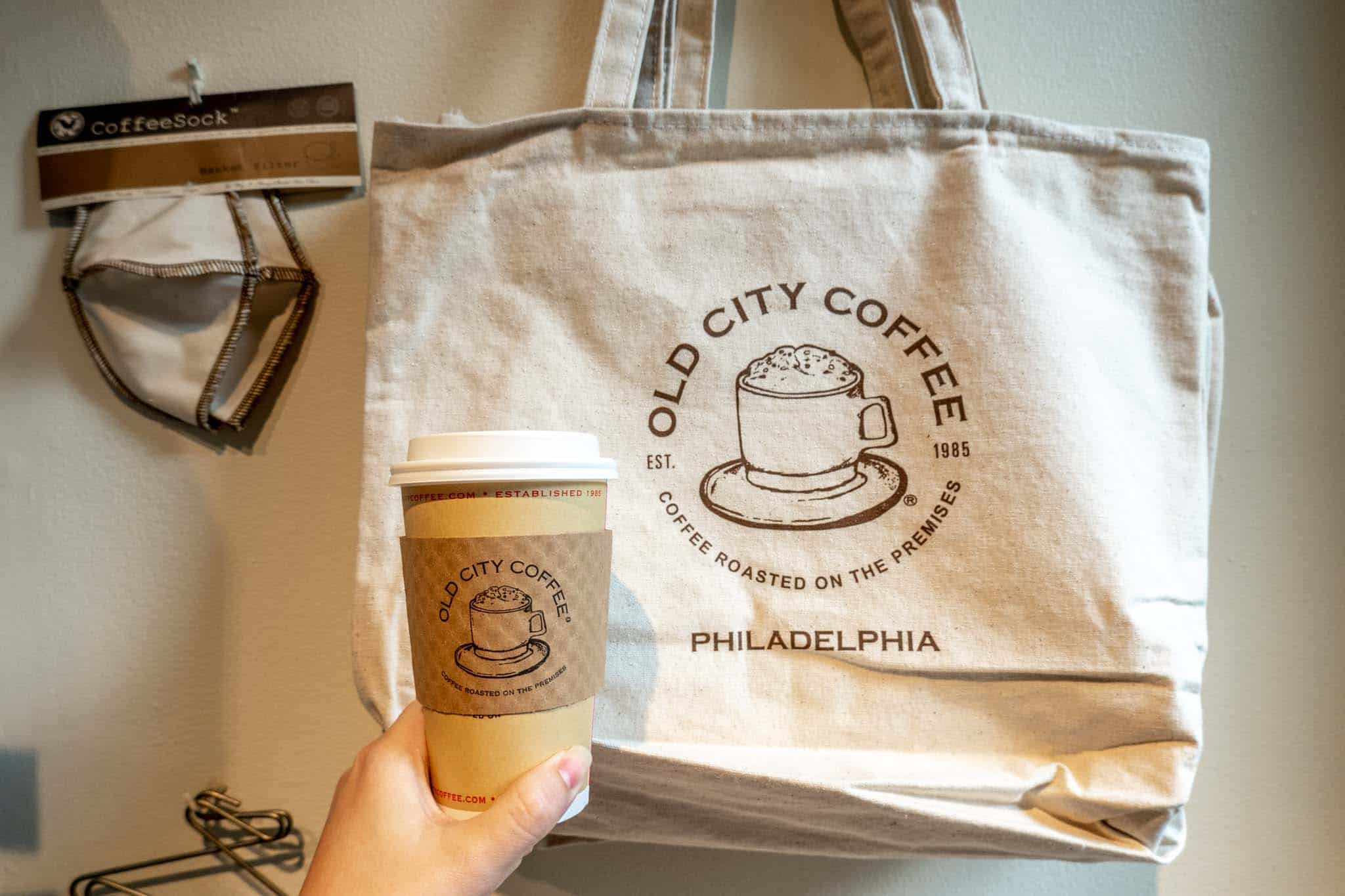 Hand holding a coffee cup with a sleeve labeled "Old City Coffee."