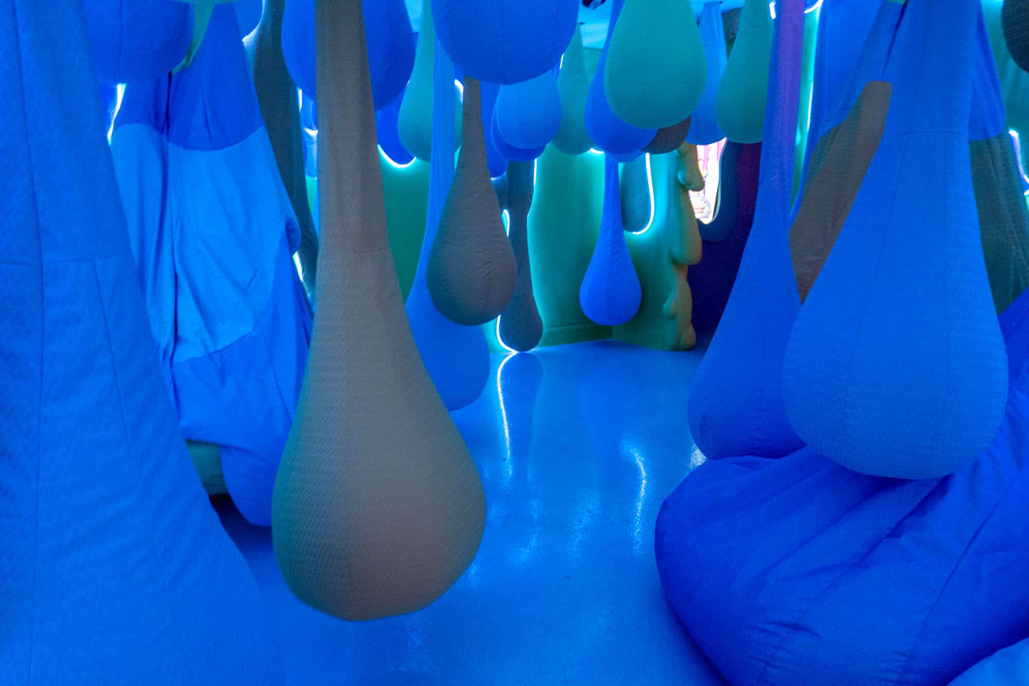 Tear drop room with suspended bean bag chairs.