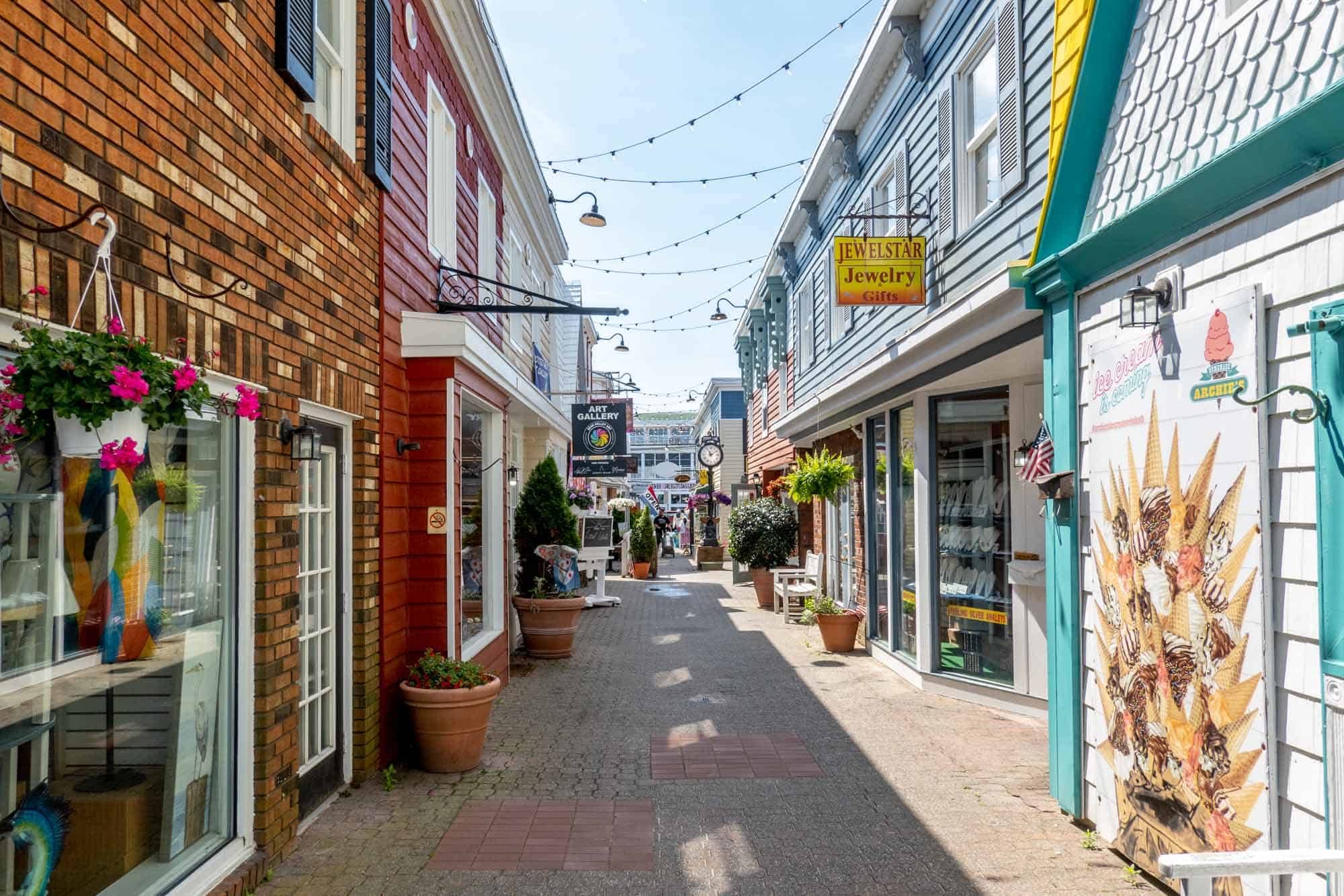 Brick and painted storefronts of businesses on a pedestrian mall.