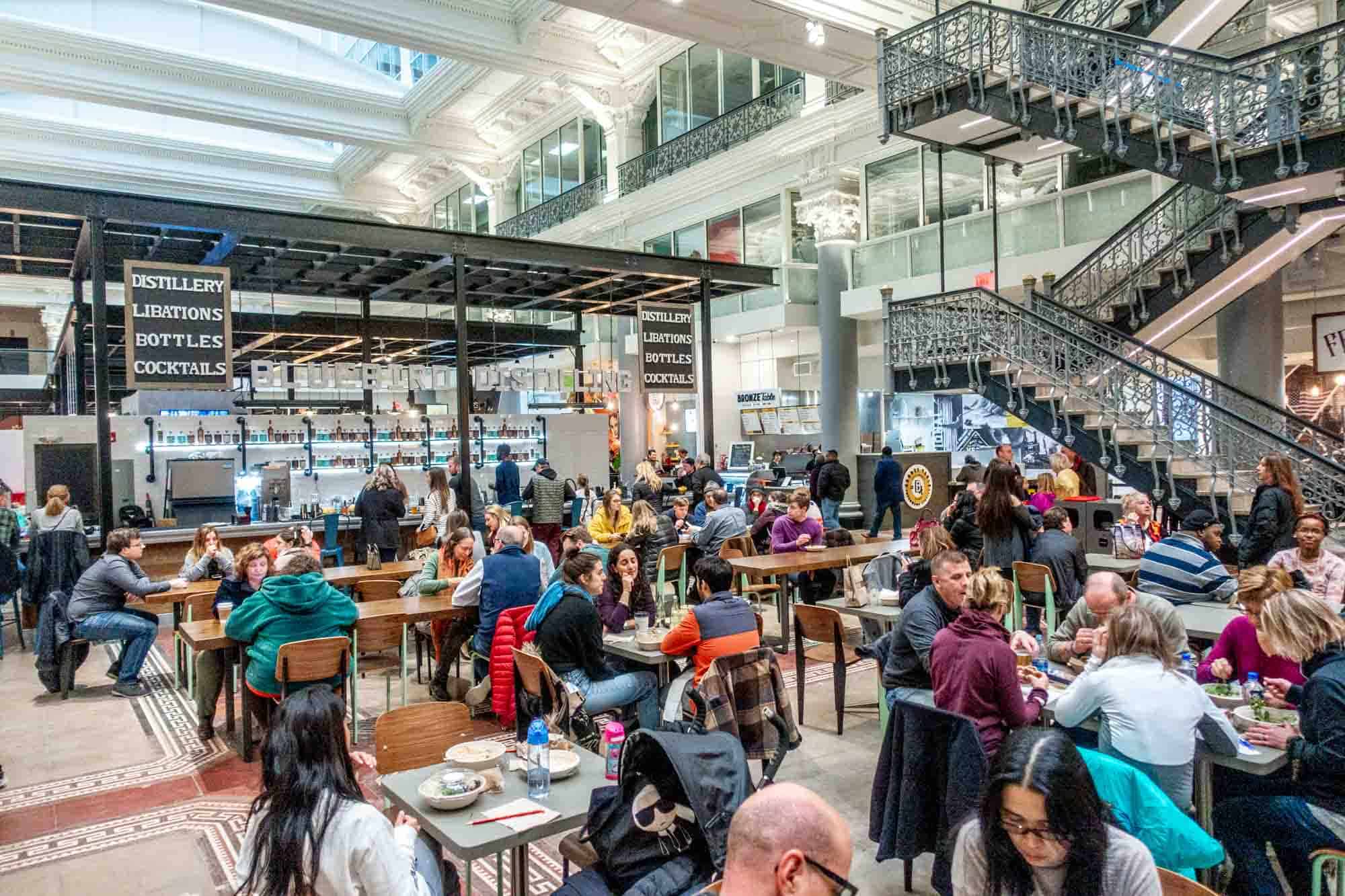 People eating at tables in a food hall.