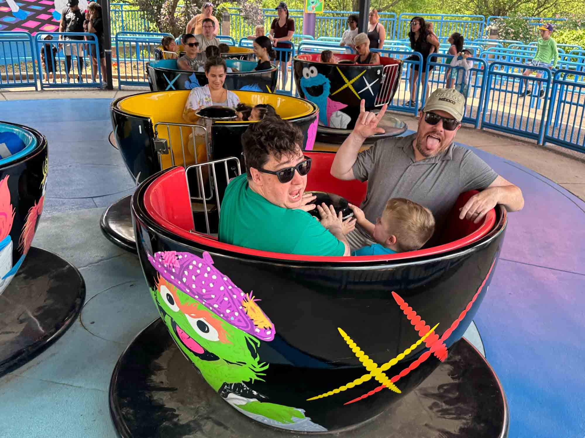 Adults and children on a teacup ride at Sesame Place.