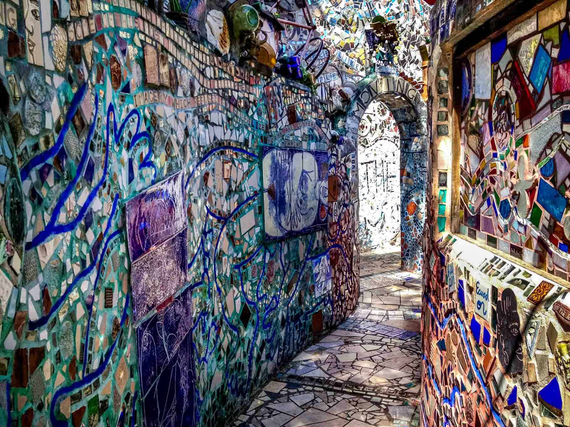 Walls and walkway covered in multi-colored mosaics.