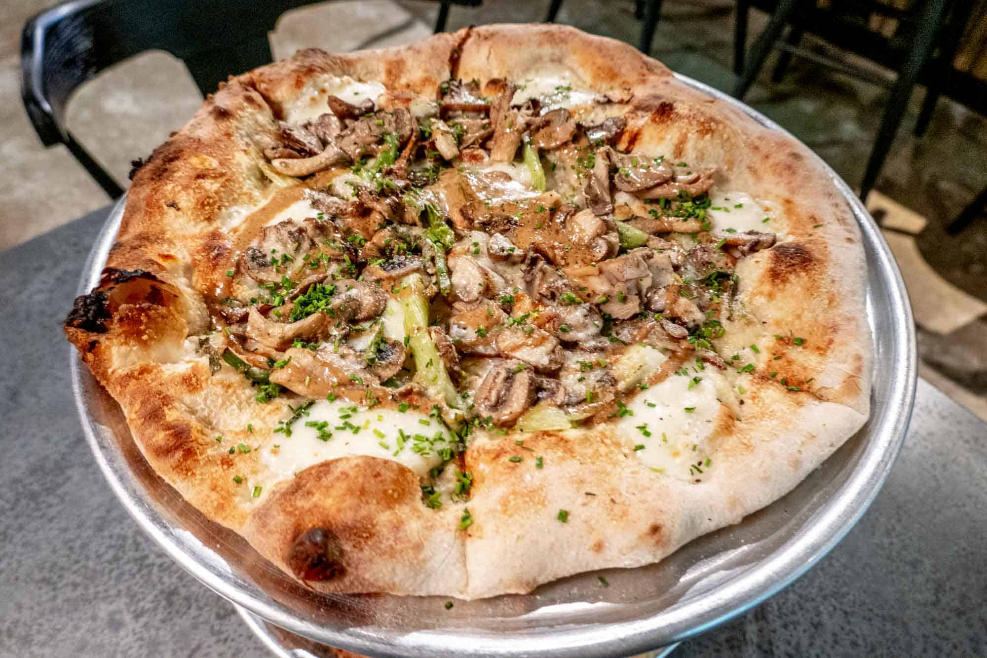 Mushroom pizza on a metal tray.