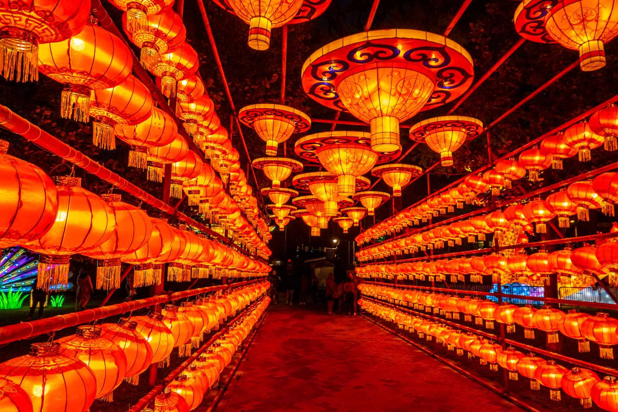 A tunnel made of red Chinese lanterns lit up at night