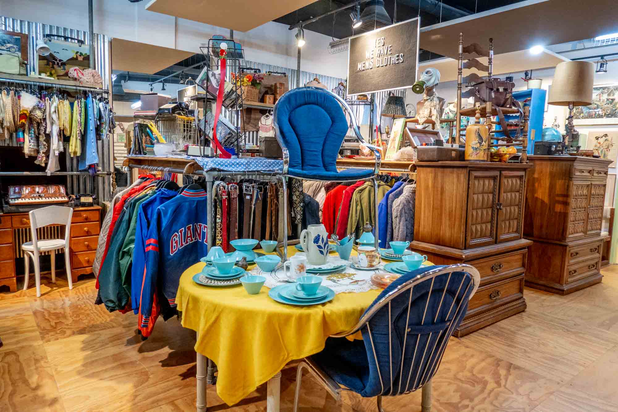Display of table with dishes and clothes from a vintage shop
