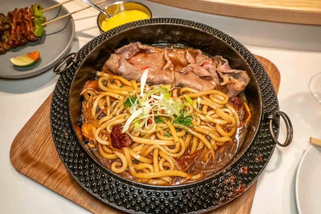 Ribeye Sukiyaki with Udon Noodles and Shiitake Mushrooms in earthenware bowl at Pod restaurant