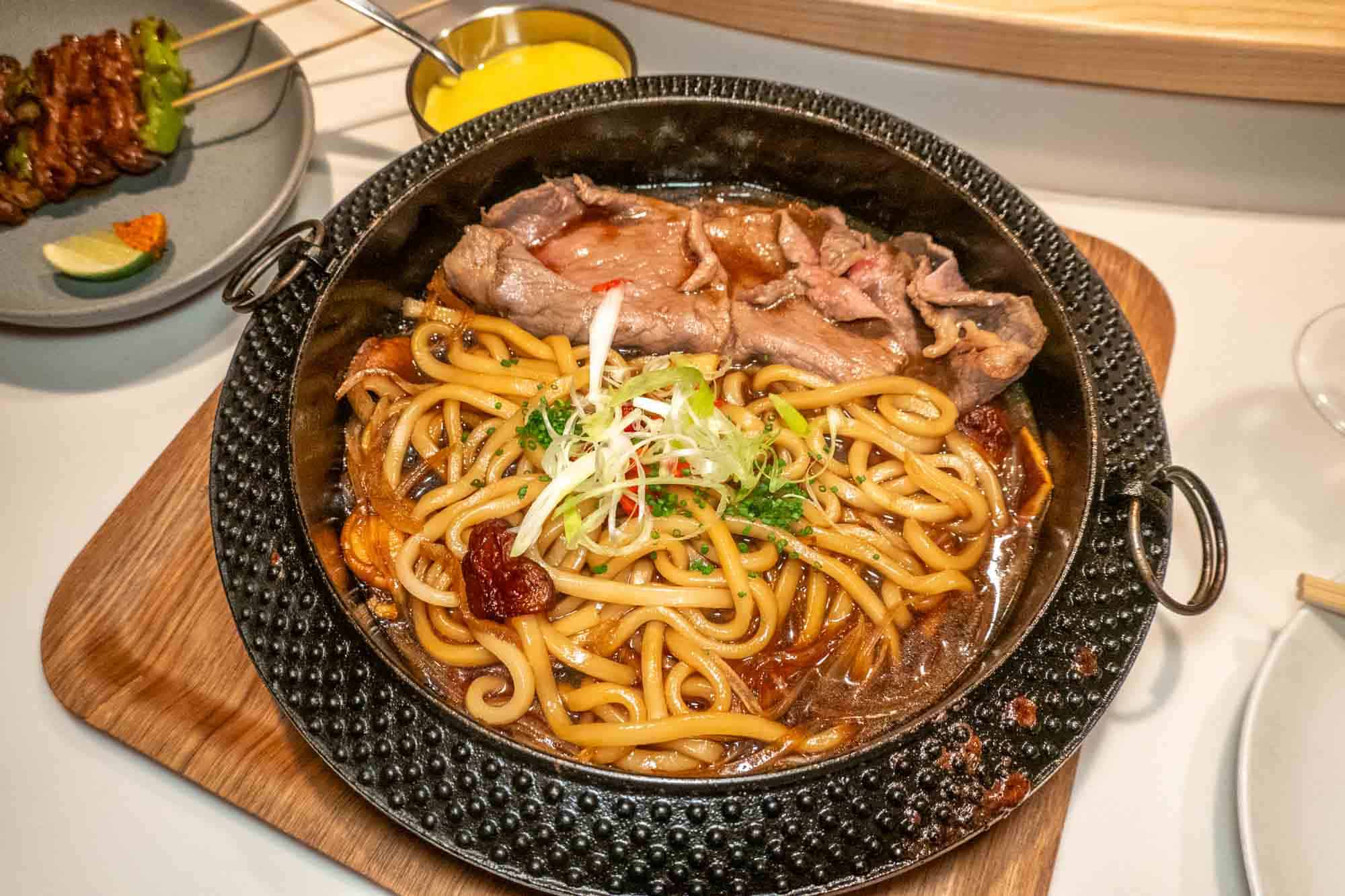 Ribeye Sukiyaki with Udon Noodles and Shiitake Mushrooms in black bowl