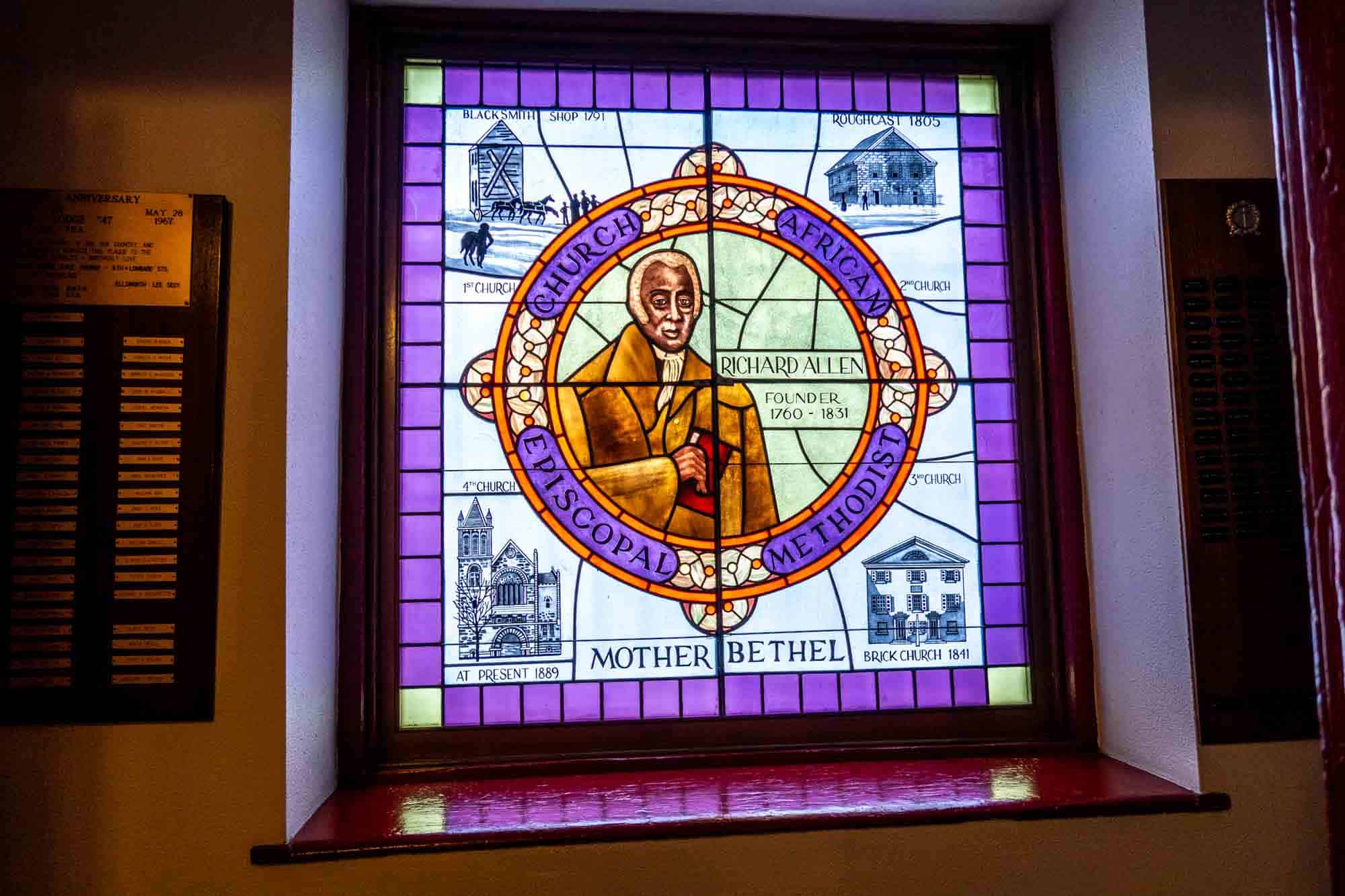 Stained glass window showing a man and four church buildings.