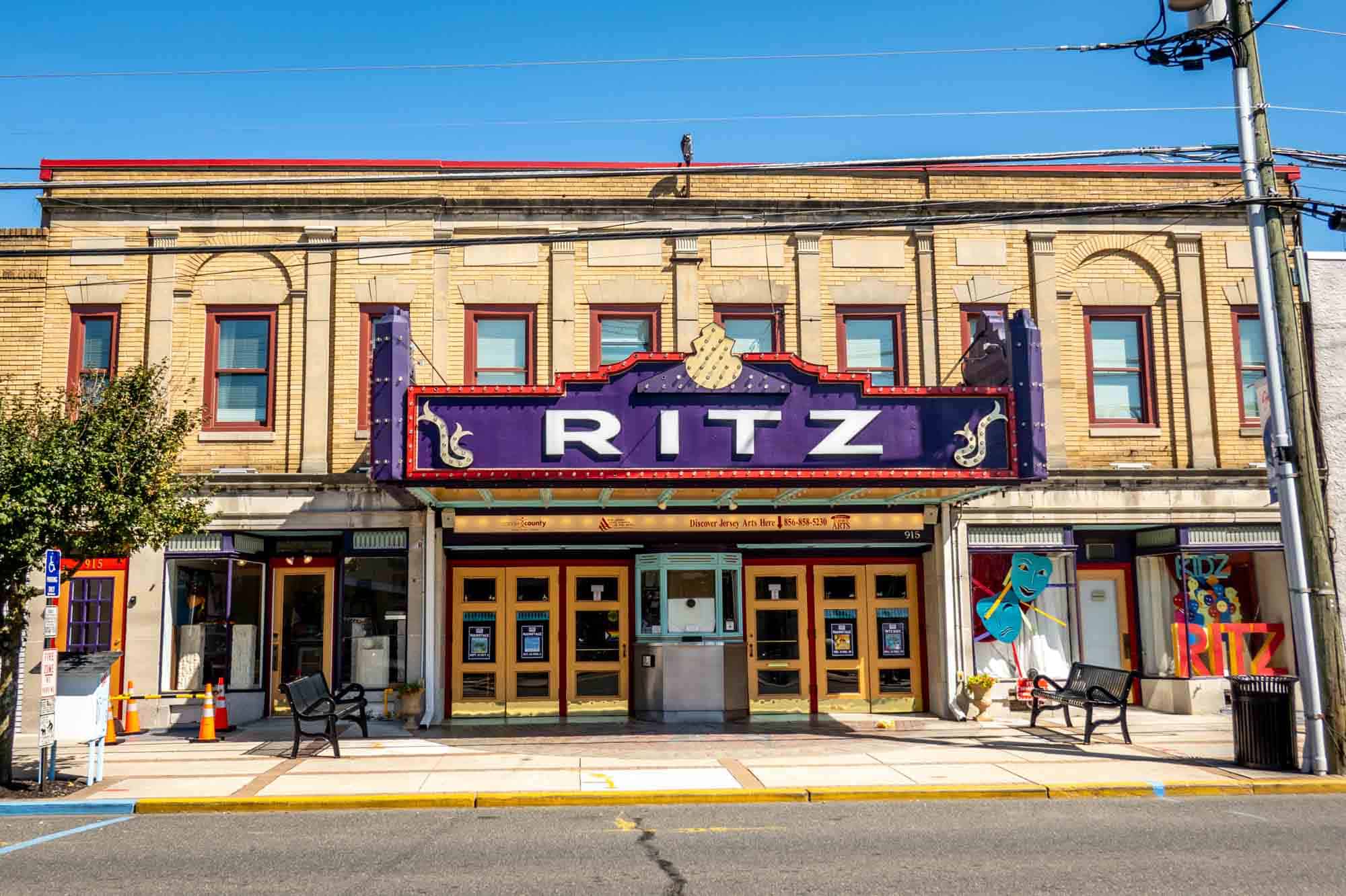Two-story building with a ticketbooth and a purple marquee: Ritz