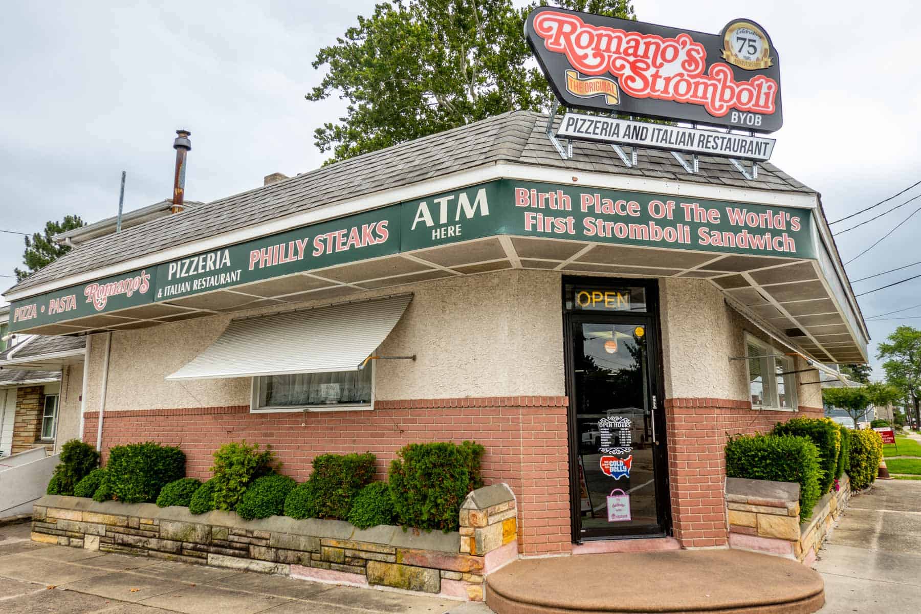 Exterior of Romano's Stromboli restaurant and a sign saying "birth place of the world's first stromboli sandwich"