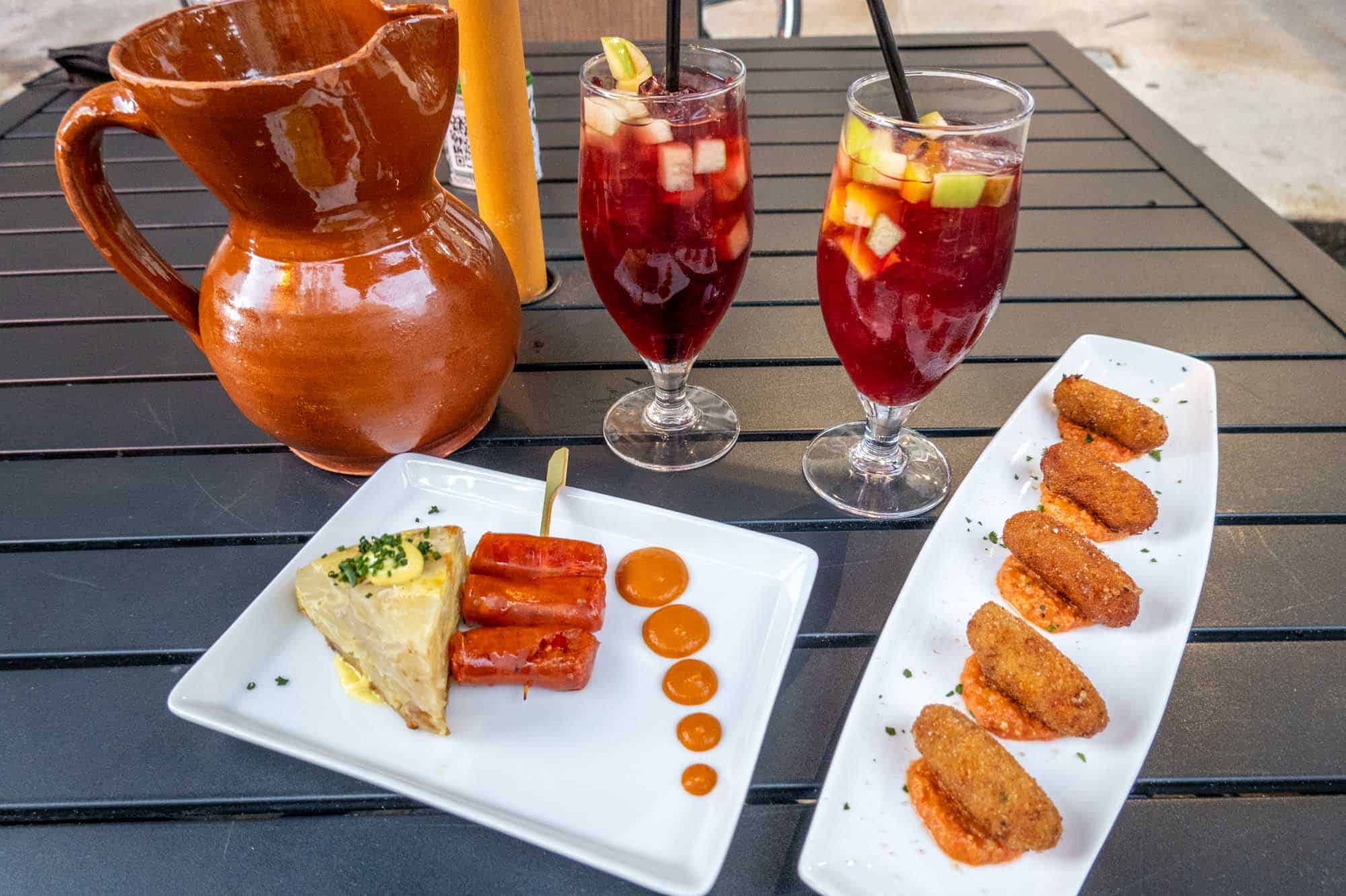 Spanish tortilla and Croquetas on plates with a drink