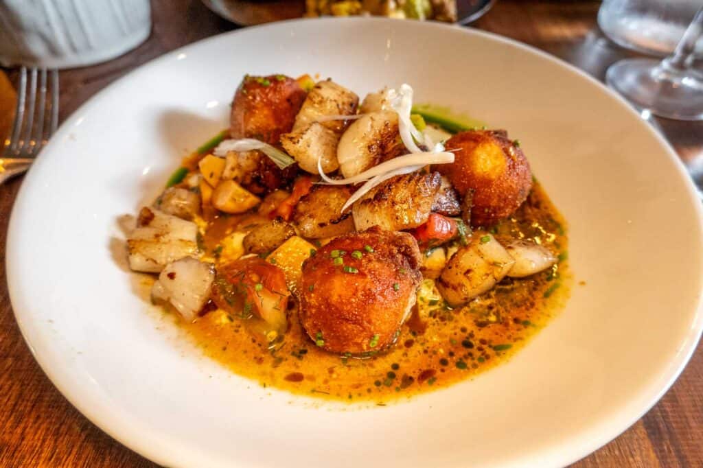 Dish of scallops, tomatoes, and fritters at Helm.