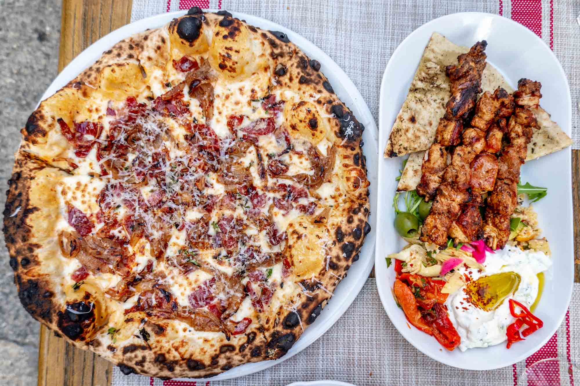 Pizza and chicken skewers on plates