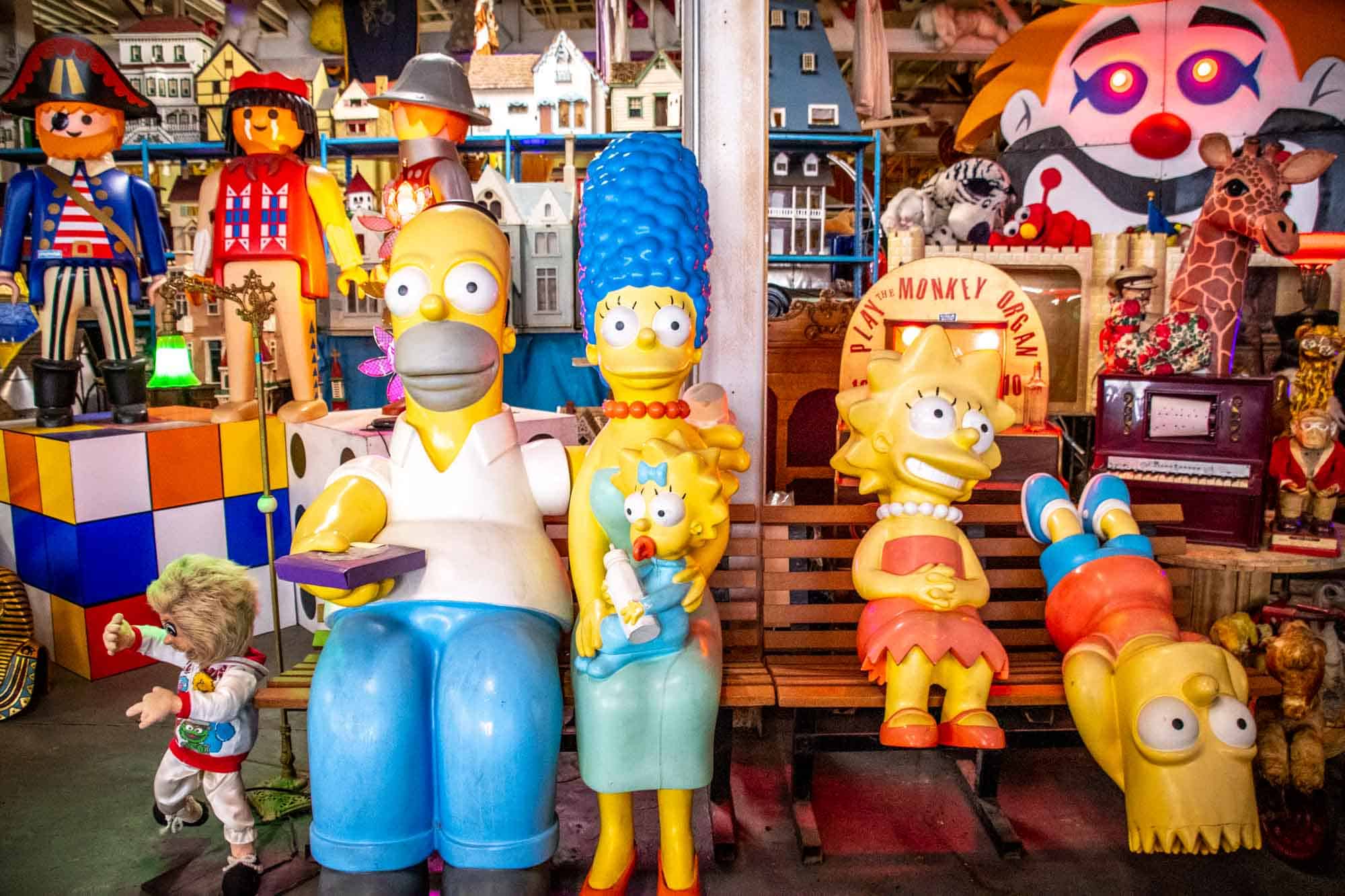 Life-sized Simpsons characters sitting on a bench beside giant Legos characters