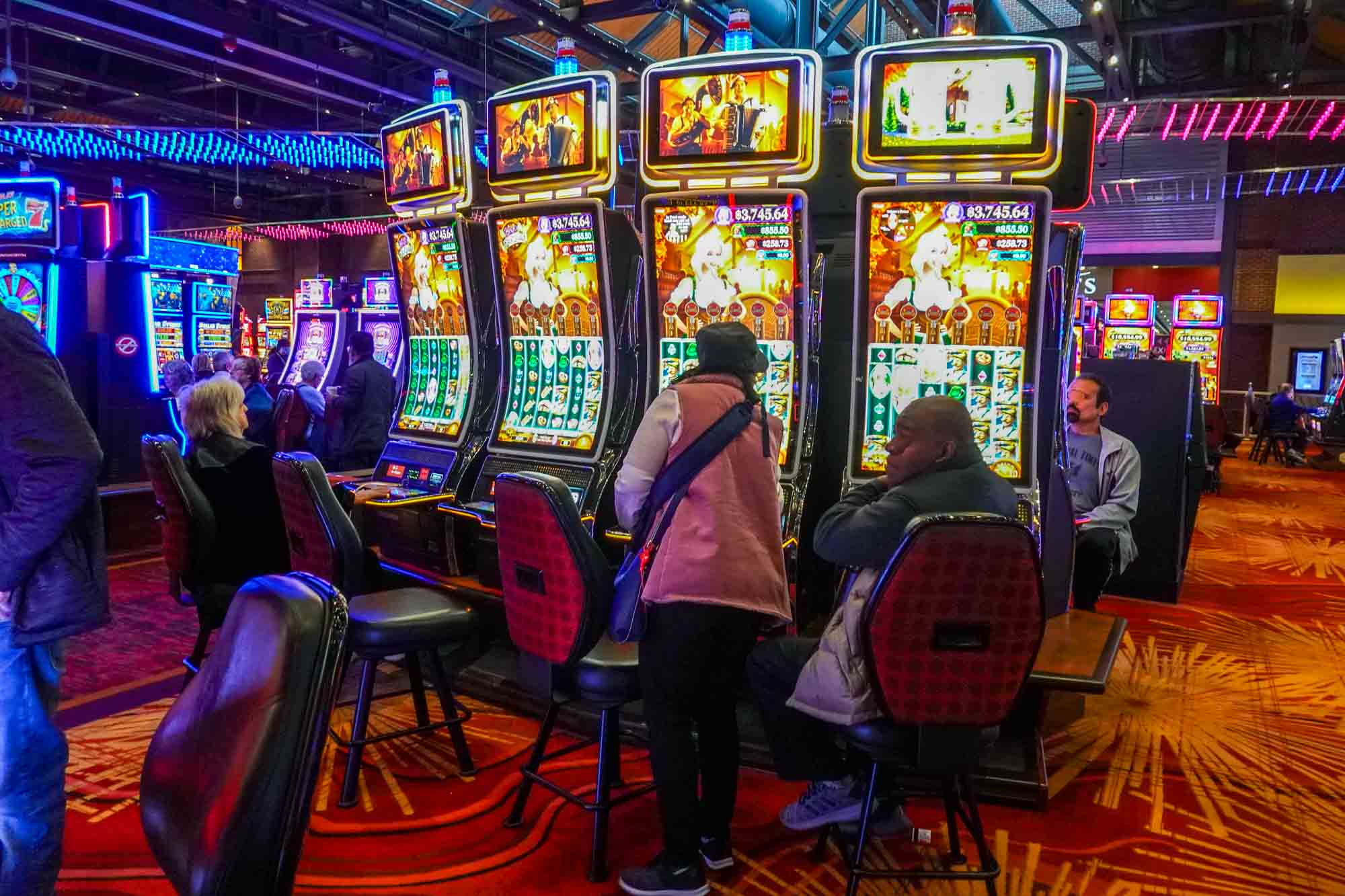 People seated at slot machines in a casino.