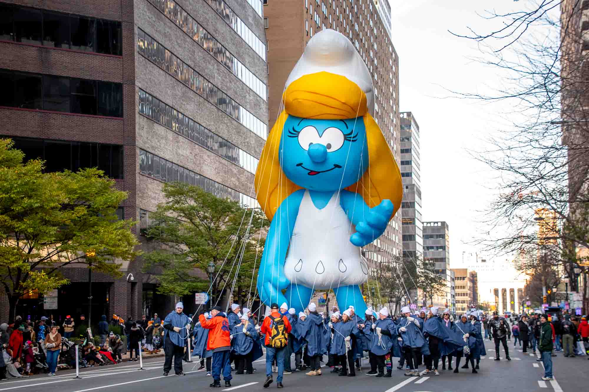 Smurfette balloon and handlers walking down street