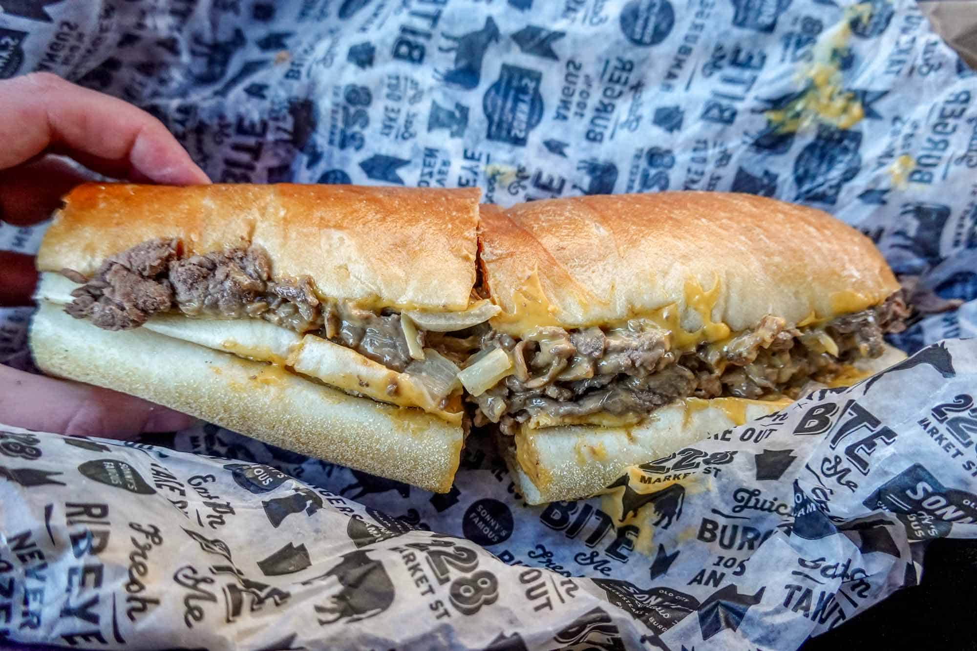 Cheesesteak on black and white paper wrapper.