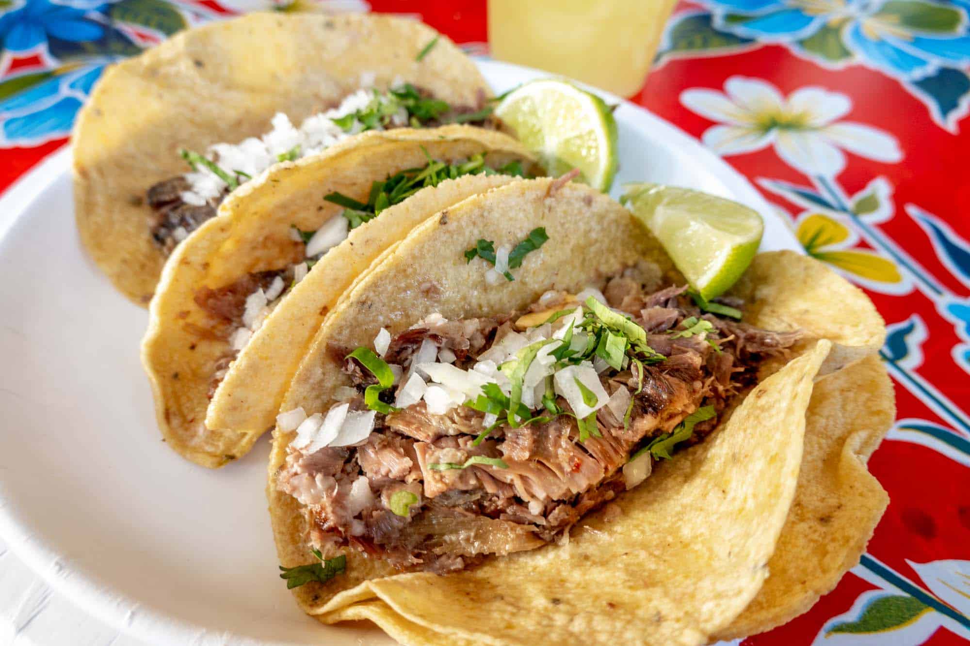 Meat tacos topped with onion and cilantro.