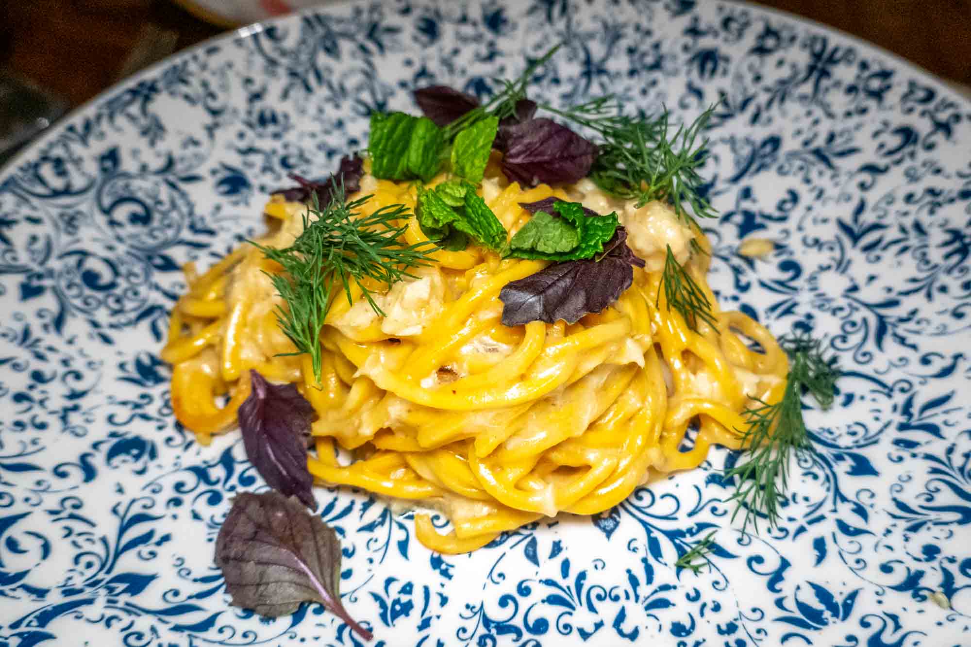 Pasta garnished with herbs on a plate.