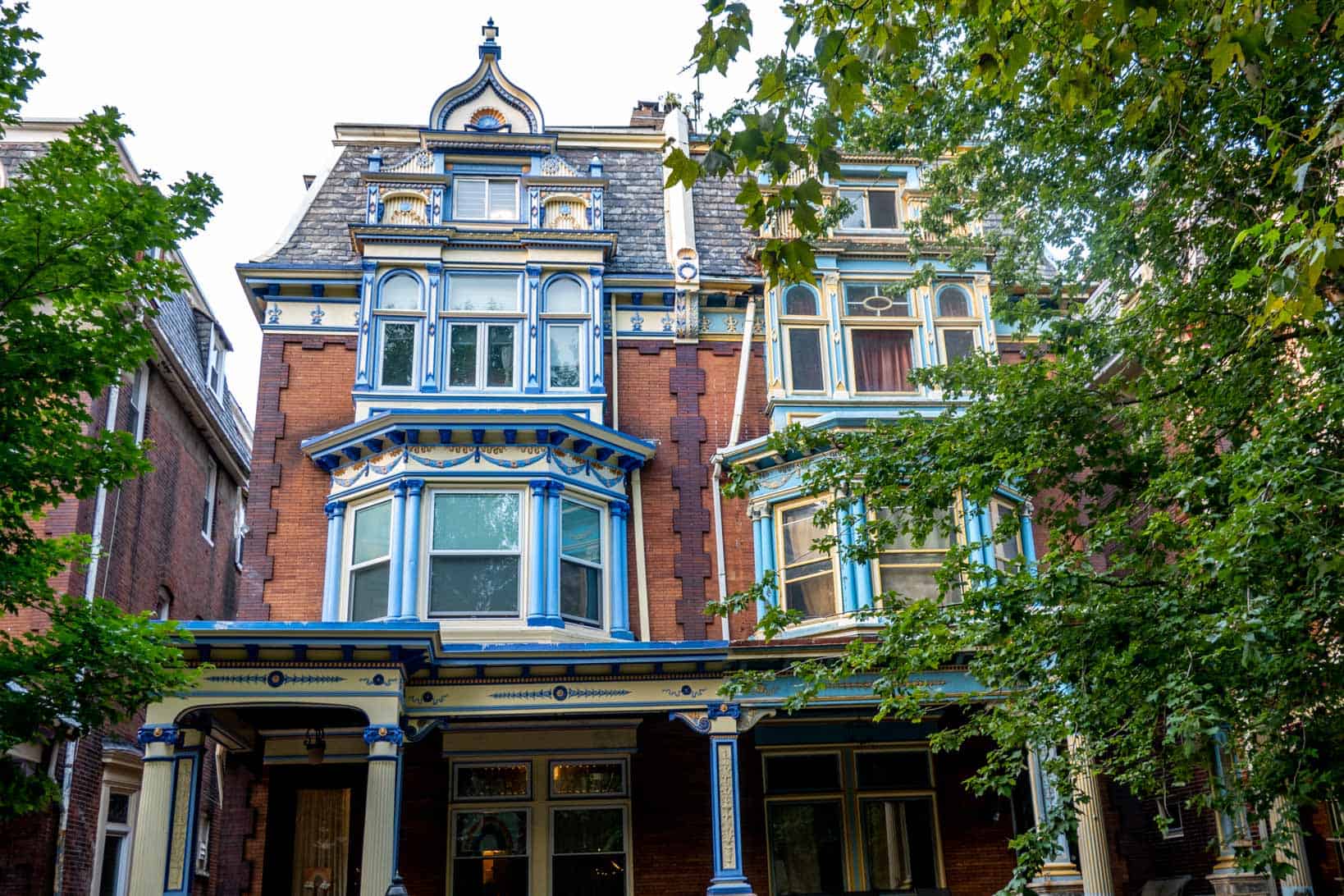 Brick Queen Anne style twin homes with blue accents.