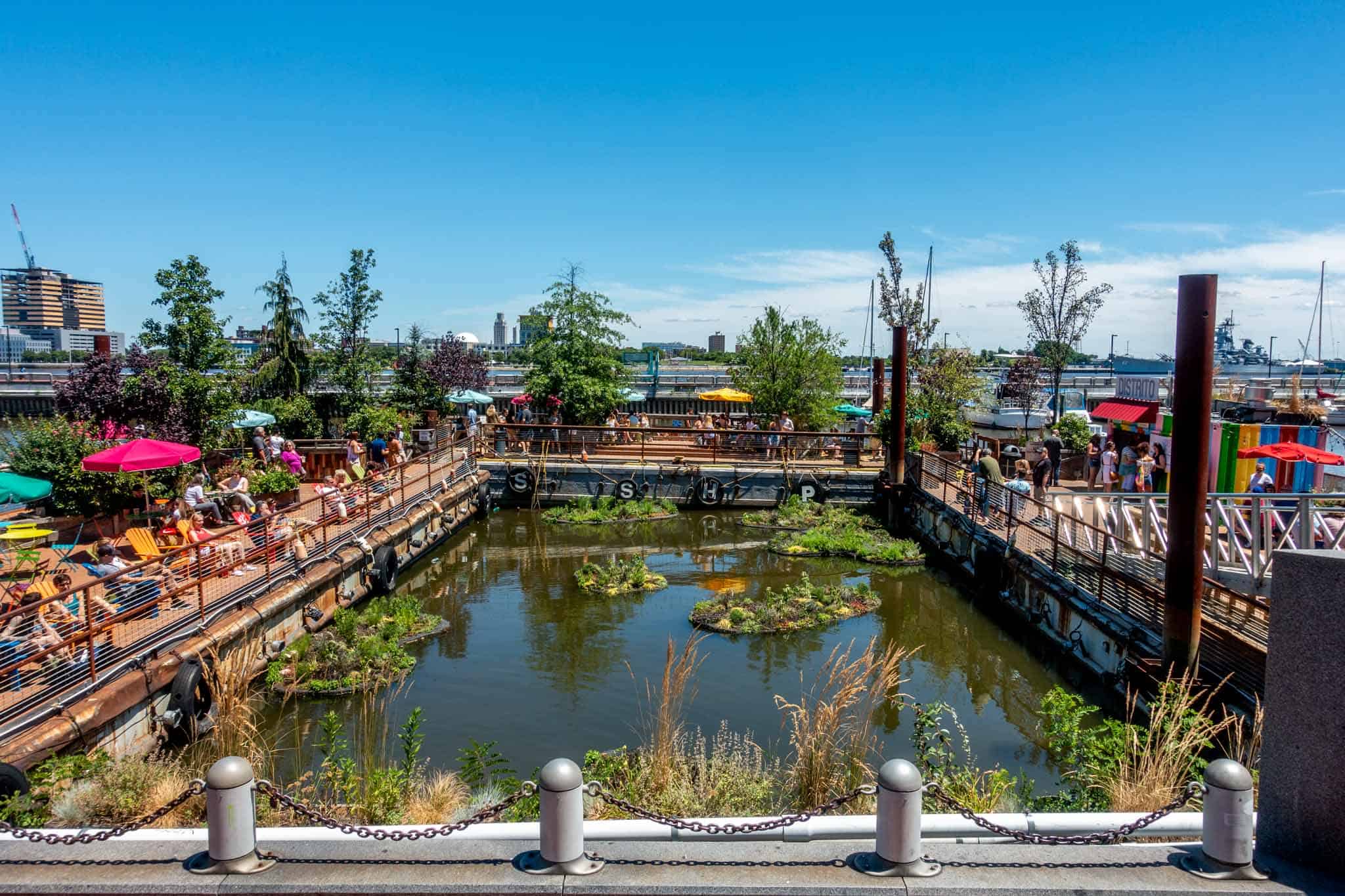 Chairs, tables, and people on colorful floating platforms.