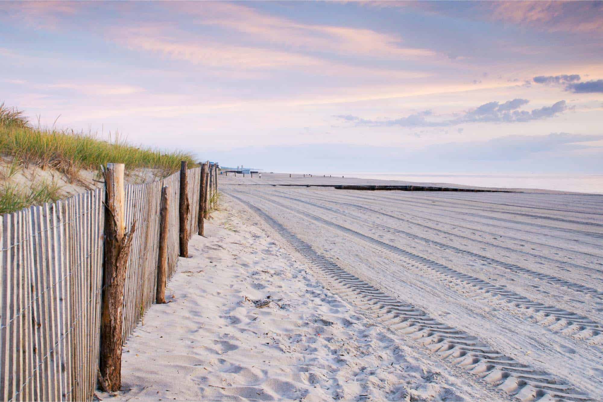 Fence and beach at sunset