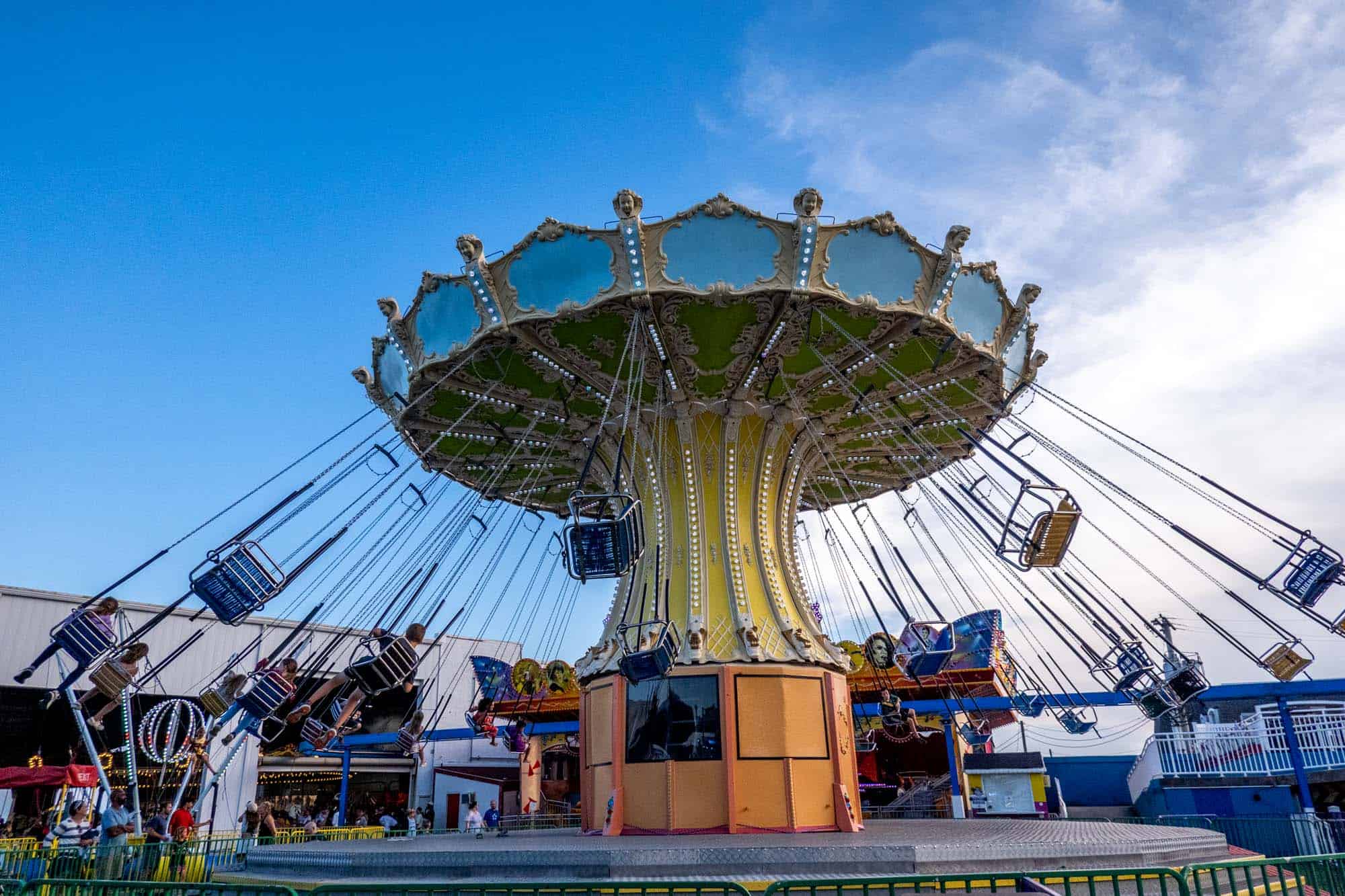 Kids spinning on a seated swing ride at an amusement park.