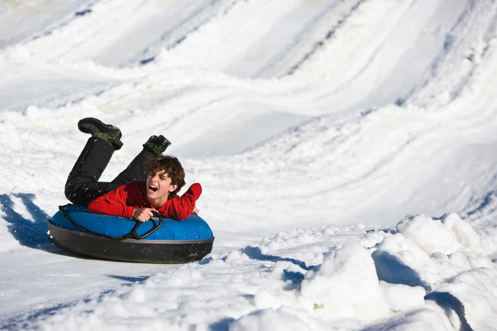 Teenager on snow tube