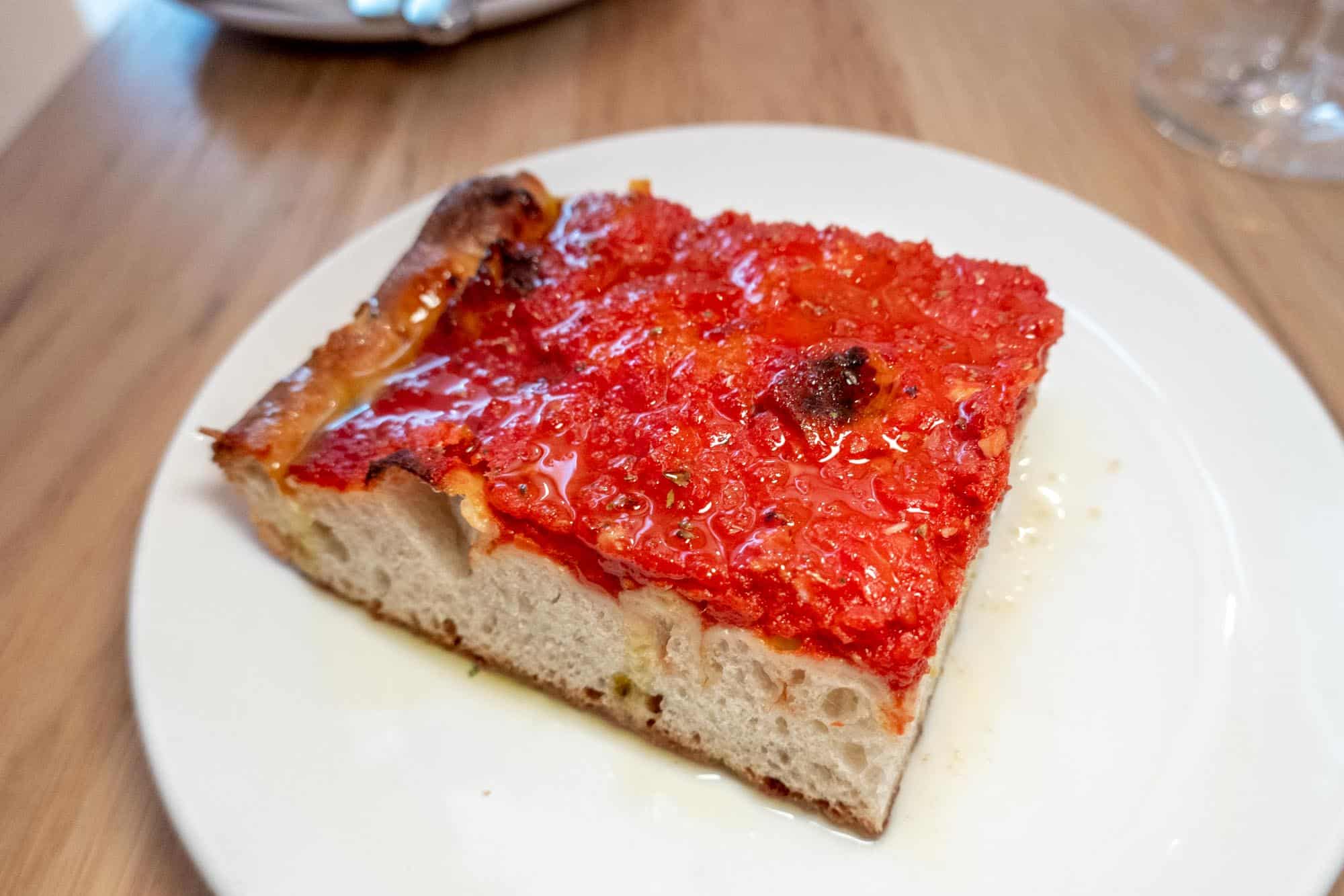 Red tomato pie on white plate