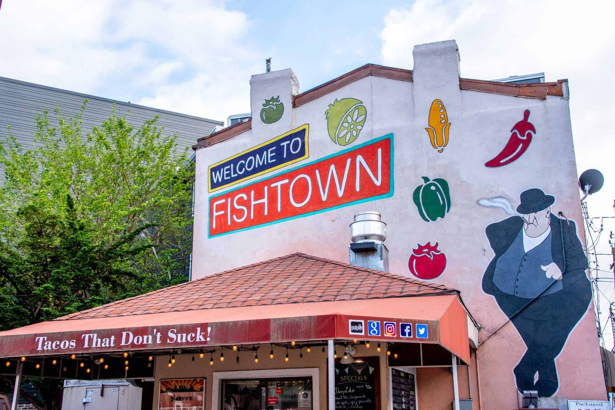 Welcome to Fishtown mural, including cartoon-style fruits and vegetable and a man with a cane