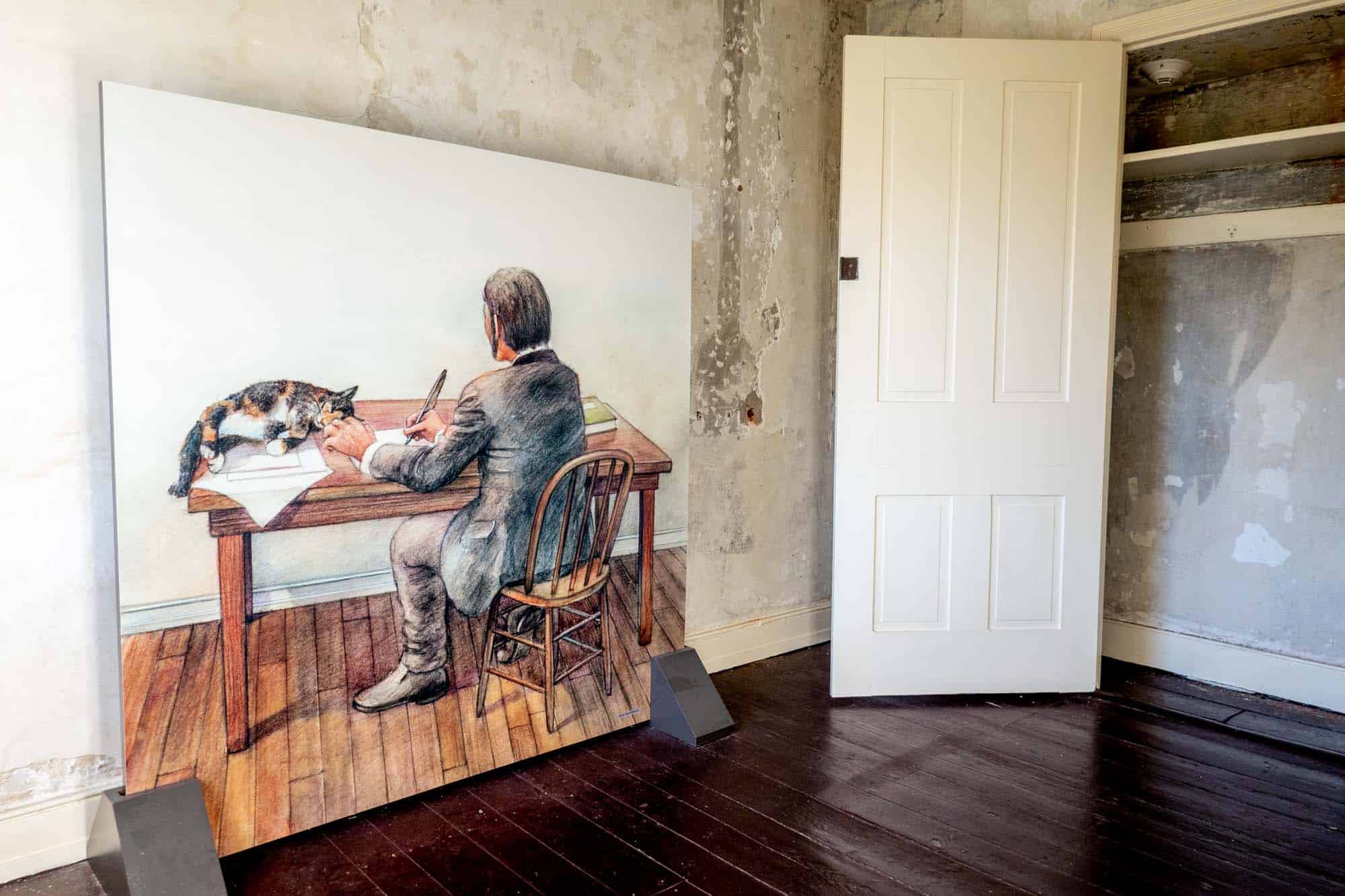 Large drawing of a man writing at a desk displayed in a house museum.