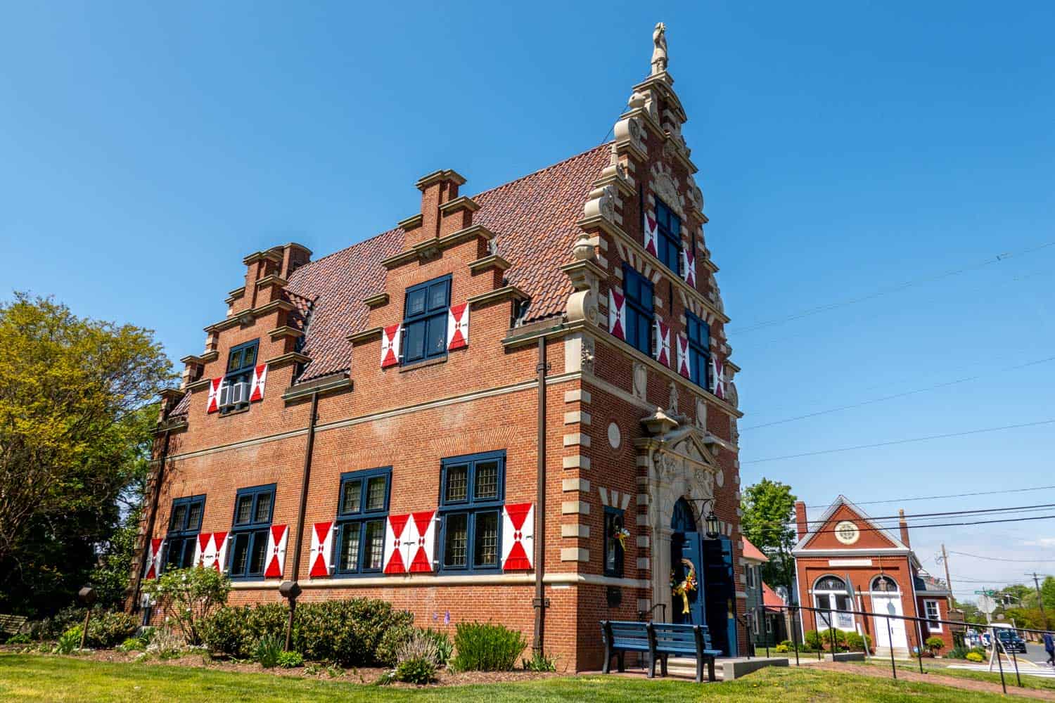 Building with red and white shutters and Dutch architecture details