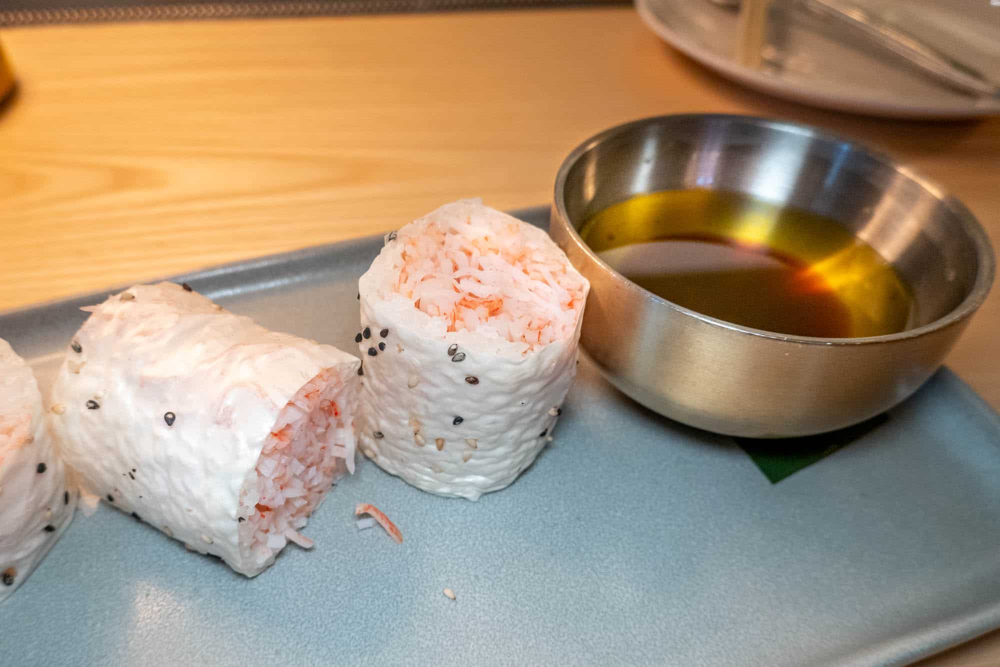 Sushi crab rolls next to bowl of butter